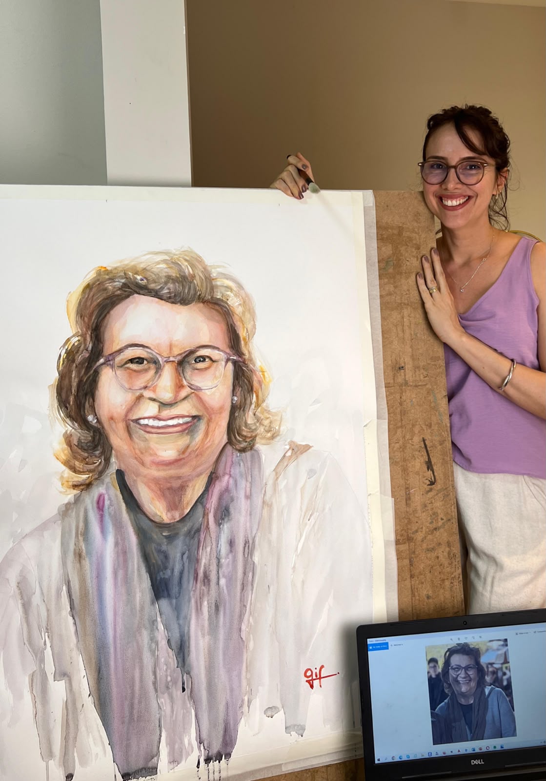 Artista ao lado de retrato grande em aquarela
